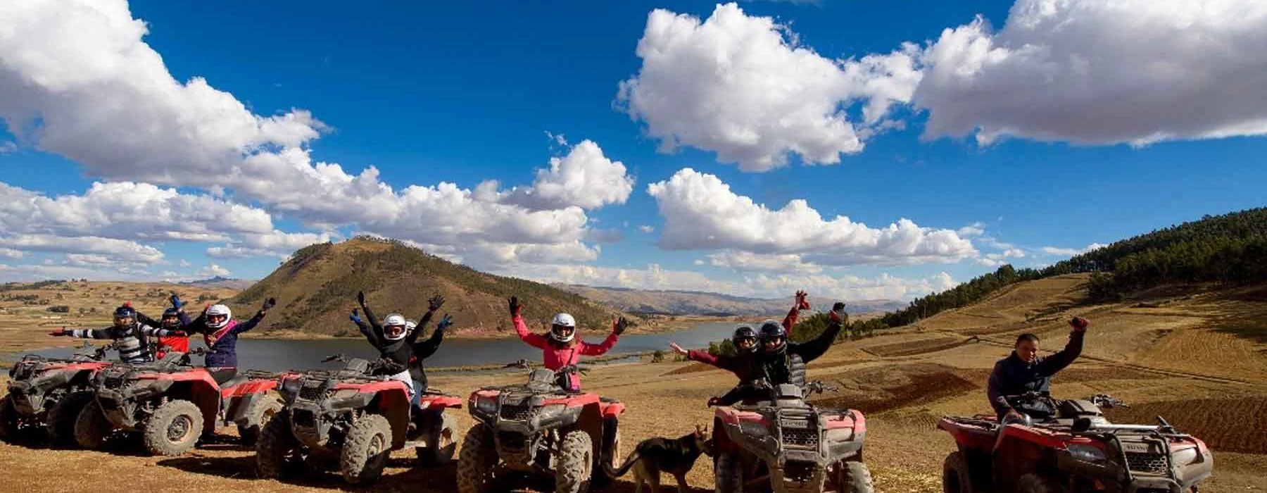 Viajeros recorriendo en cuatrimotos el paisaje junto a una laguna de Cusco